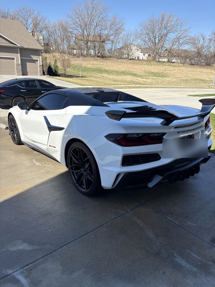 Glossy white Corvette C8 Z06 from rear 3/4 angle with carbon wing
