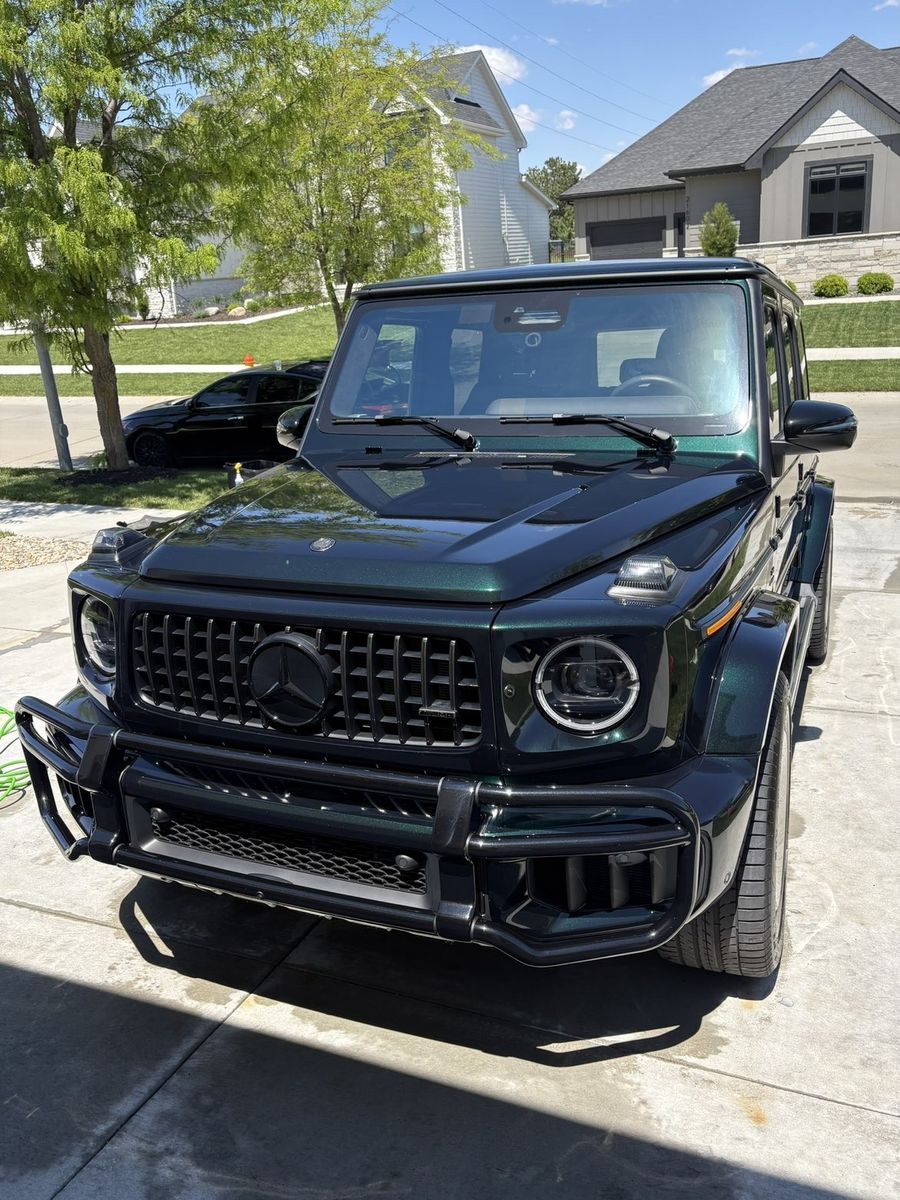Glossy emerald-green Mercedes G63 AMG front 3/4 angle in driveway after detailing