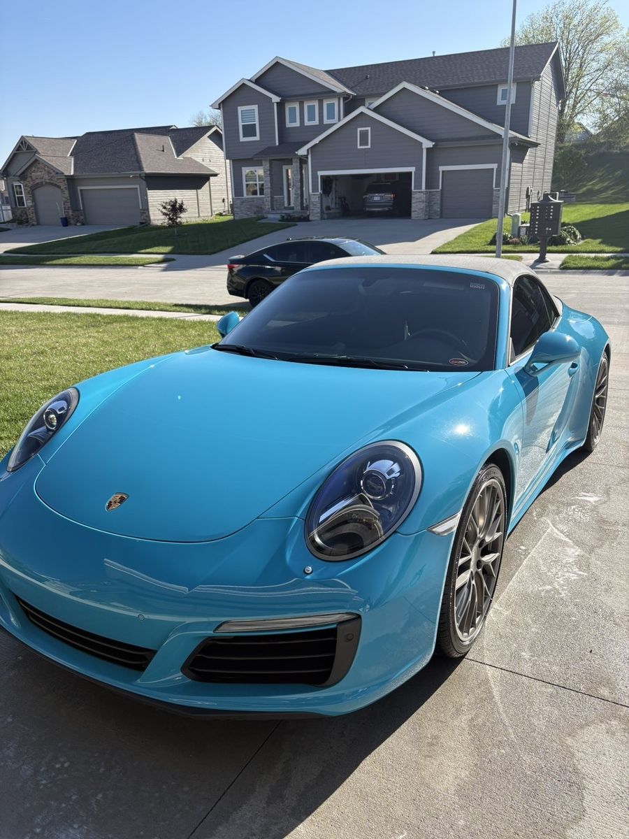 Rear 3/4 view of clean Porsche 911 Carrera with soft top up